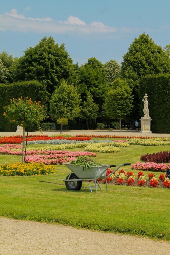 Vibrant flower beds and a wheelbarrow in a garden at Schönbrunn Palace, Vienna.